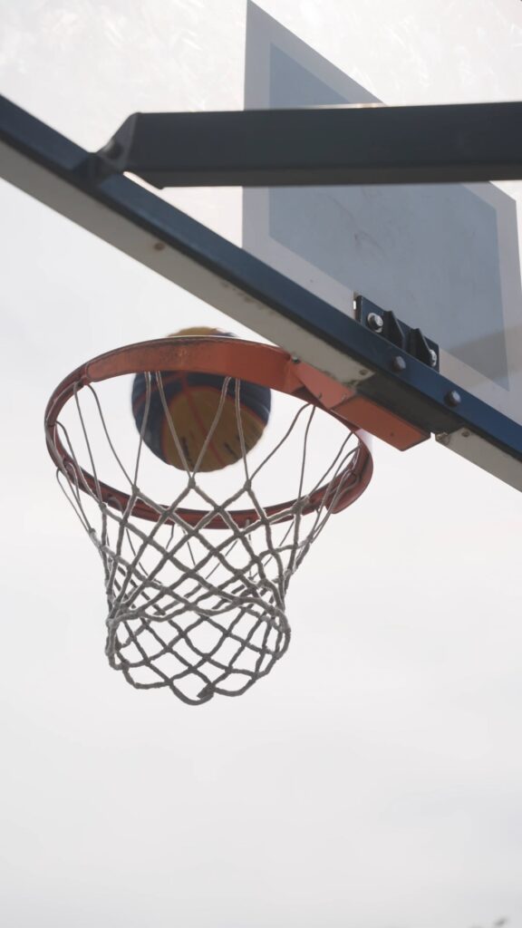 Dynamische Sport Sfeervideo Close-up van een basketbal die door de ring gaat, een voorbeeld van dynamische actiebeelden voor sfeervideo's.