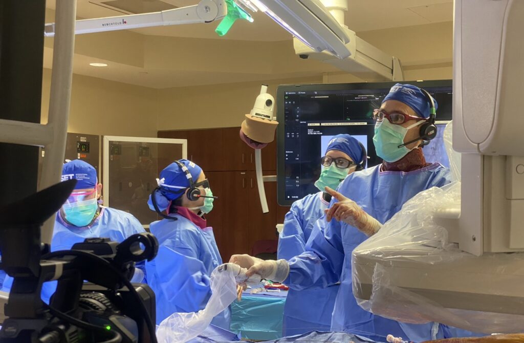 Overzichtsfoto van een moderne operatiekamer met focus op de videoschermen en technische ondersteuning van de ingreep.